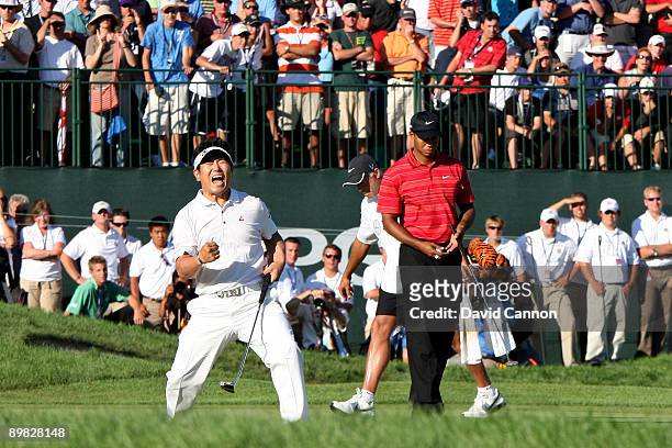 Yang of South Korea celebrates a birdie putt on the 18th green alongside Tiger Woods during the final round of the 91st PGA Championship at Hazeltine...