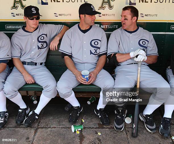 Chris Getz, Paul Konerko and Jim Thome of the Chicago White Sox get ready in the dugout before the game against the Oakland Athletics during the...