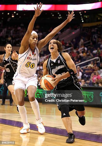 Becky Hammon of the San Antonio Silver Stars drives to the basket past Tangela Smith of the Phoenix Mercury during the WNBA game at US Airways Center...