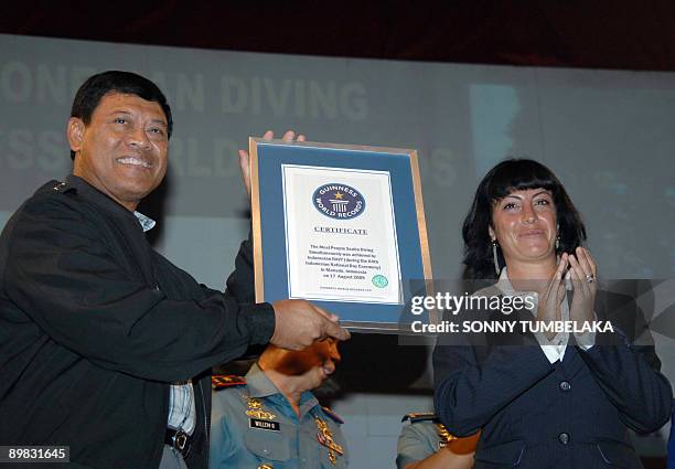 Guinness adjudicator Lucia Sinigagliesi of Guiness World Record applauds after handing the certificate of Guinness World Record to Indonesian Navy...