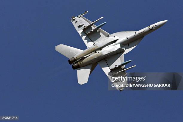 This photograph taken on February 10 shows a US Navy F/A-18F Super Hornet strike aircraft performing a roll during a flight demonstration at the...