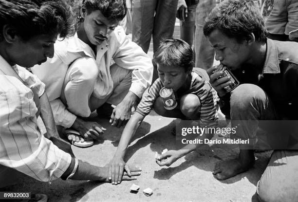 Street children in Grant Road, sniff glue while gambling. Bribing the local policemen 5 rupees a day enables them to run a gambling den.