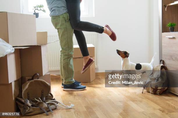 happy man lifting woman in new house - first apartment stock pictures, royalty-free photos & images