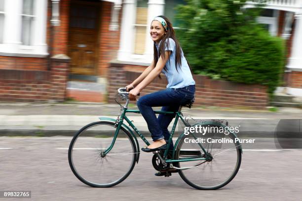 mixed-race teenager riding bicycle - girl bike stock pictures, royalty-free photos & images