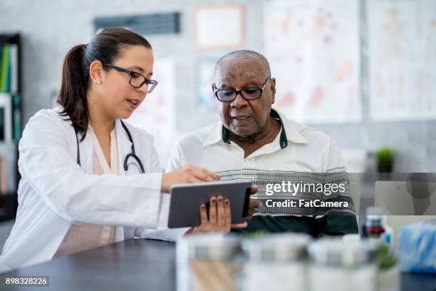 arts met een tabletcomputer - health care professional with patient stockfoto's en -beelden