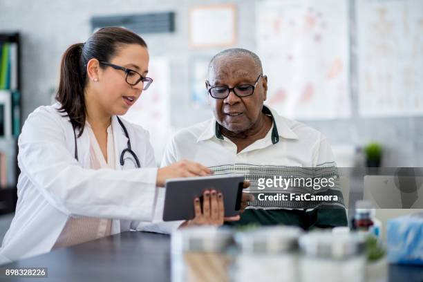doctor with a tablet computer - explaining stock pictures, royalty-free photos & images