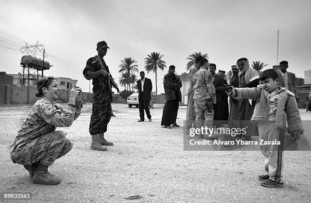 Major Megan McLung from Coupeville, takes a photo of the son of one of the most important tribal families in Ramadi, a new ally of the US army in...