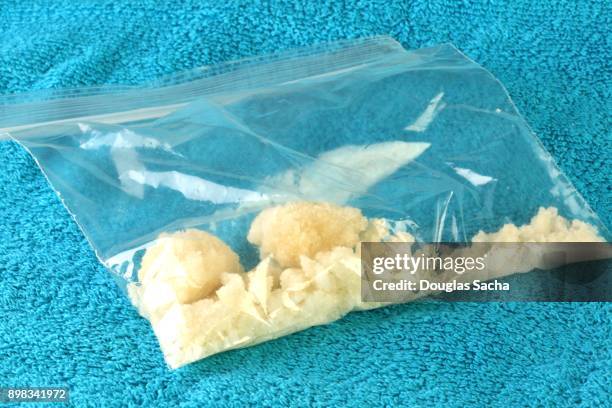 bag of illegal drugs on a blue background - crack cocaine stock pictures, royalty-free photos & images