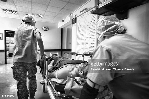 Medics move a soldier fighting for his life to the emergency room, at the 28th CSH known as 'China Dragon', at Baghdad hospital.