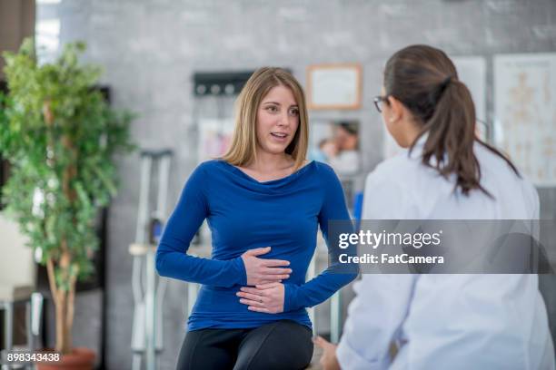 mujer con dolor de estómago - stomachache fotografías e imágenes de stock