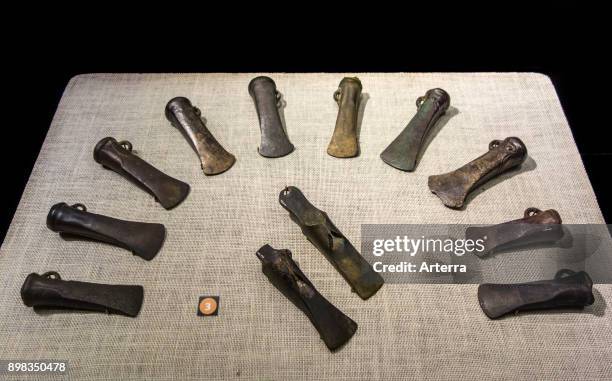 Collection of winged axes and bronze socketed axes, linear facetted axe heads from the Late Bronze Age.