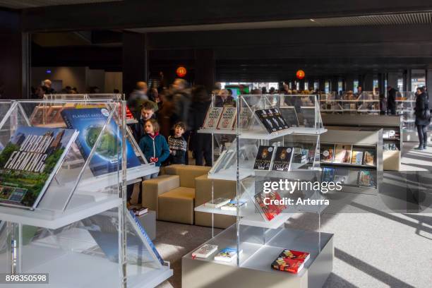 Visitors looking at books in De Krook, new public library in the city center of Ghent, East Flanders, Belgium.