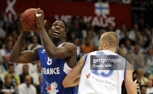 French Ian Mahinmi tries to score past Finland's Hanno Möttölä during the basketball Euro Championships qualification match in Vantaa, Finland on...