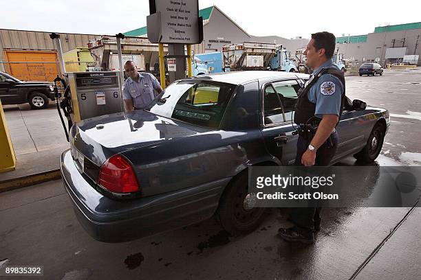 Police officers Kirby Ball and Juan Campos fuel up a squad car at a City of Chicago fuel site August 17, 2009 in Chicago, Illinois. The fuel site is...