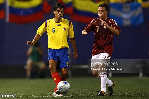 Fabian Vargas of Columbia kicks past Jose Manuel Rey of Venezuela during their match at Giants Stadium on August 12, 2009 in East Rutherford, New...