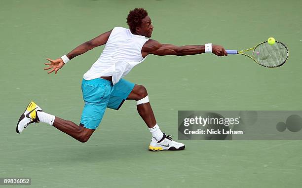 Gael Monfils of France hits a backhand against Ivo Karlovic of Croatia during day one of the Western & Southern Financial Group Masters on August 17,...