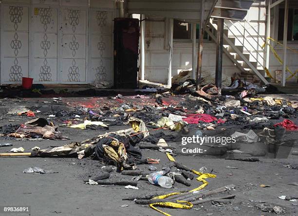 Burnt clothes and debris remain outside the scene of a wedding party fire in Jahra, west of Kuwait City, on August 17 one day after a raging blaze...