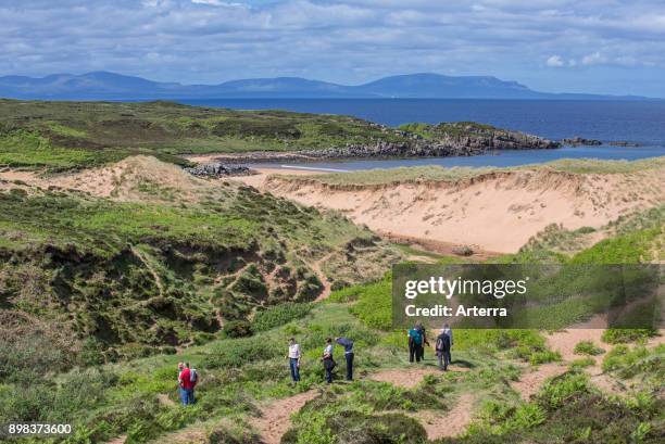 Tourists walking in the dunes and at Red Point / Redpoint, Ross and Cromarty, Scottish Highlands, Scotland, UK.