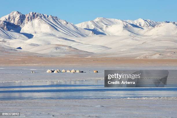 Yurts in traditional Kyrgyz yurt camp in the snow along Song Kul / Song Kol lake in the Tian Shan Mountains, Naryn Province, Kyrgyzstan.