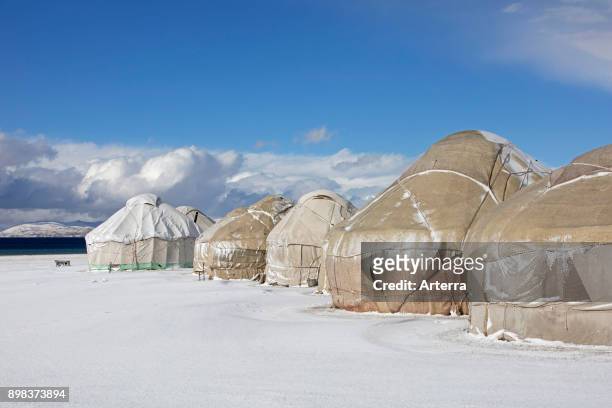 Yurts in traditional Kyrgyz yurt camp in the snow along Song Kul / Song Kol lake in the Tian Shan Mountains, Naryn Province, Kyrgyzstan.