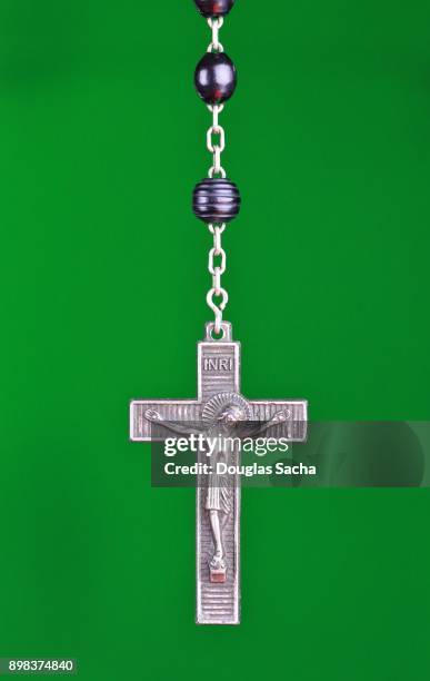 religious rosary praying beads on a green background - jesus and mary chain stock pictures, royalty-free photos & images