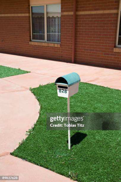 a postbox on a lawn outside of a house - mailbox stock pictures, royalty-free photos & images