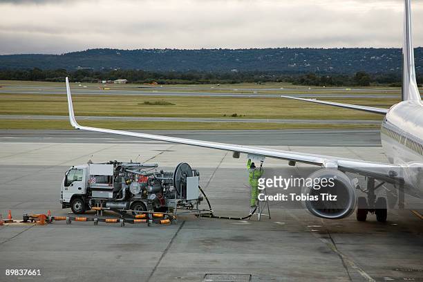 an airplane being refueled on the tarmac - aircraft refuelling stockfoto's en -beelden