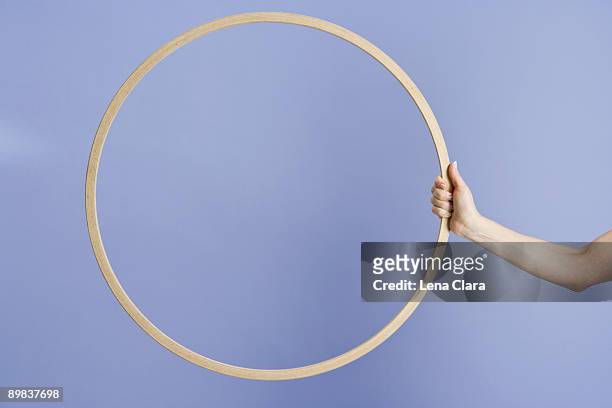 a woman holding a plastic hoop - hoelahoep stockfoto's en -beelden