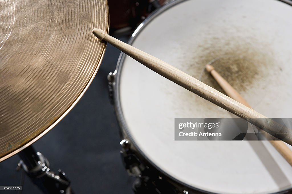 Detail of drumsticks and a drum kit