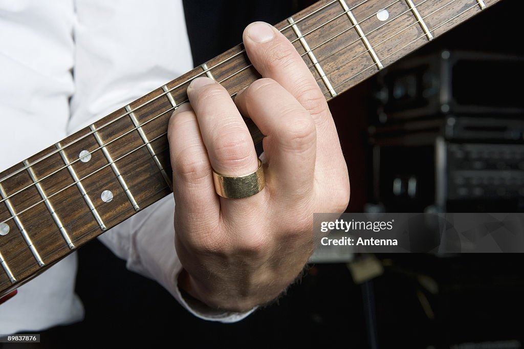Detail of a man playing an electric guitar