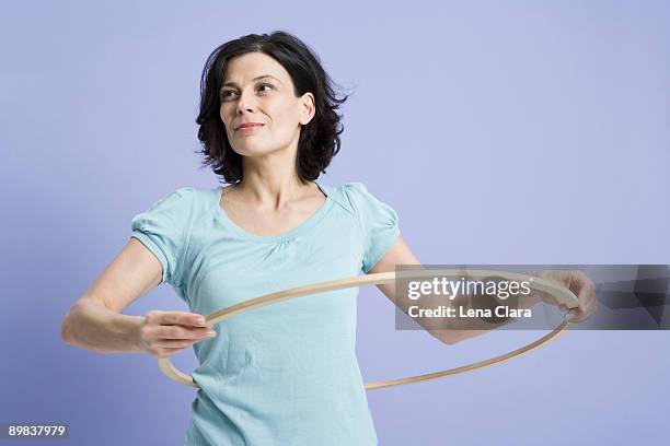 a woman using a hula hoop - gymnastikreifen stock-fotos und bilder