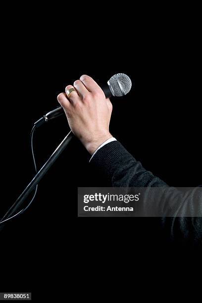 detail of a man holding a microphone - microphone stand stock pictures, royalty-free photos & images