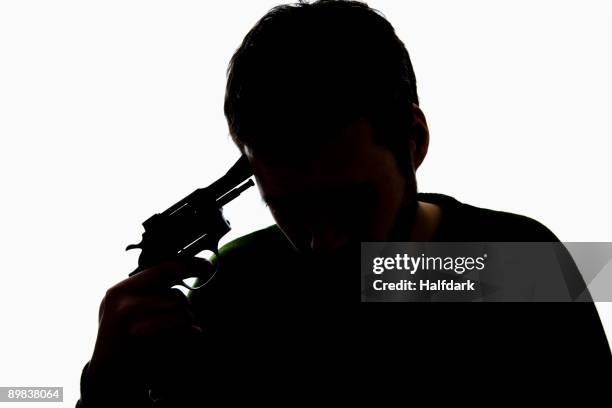 a man holding a gun to his head - person with gun against head silhouette stock pictures, royalty-free photos & images
