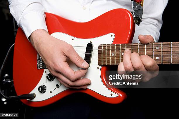 detail of a man playing an electric guitar - red electric guitar stock pictures, royalty-free photos & images