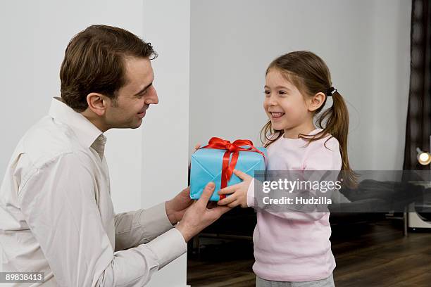 a father giving his daughter a present - child giving gift ストックフォトと画像