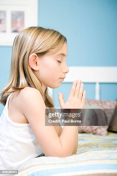 young girl kneeling near bed and praying - child praying stock pictures, royalty-free photos & images