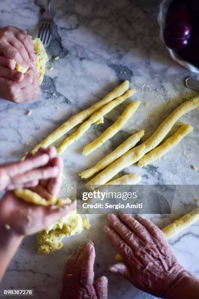 shaping potato dough into thumb-thick logs before cutting them in small pieces - log rolling stock pictures, royalty-free photos & images