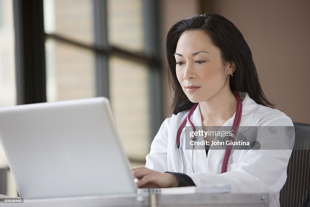 Doctor entering information into computer.