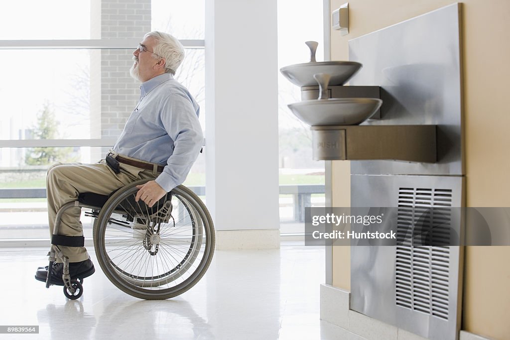 Business man in wheelchair in a corridor