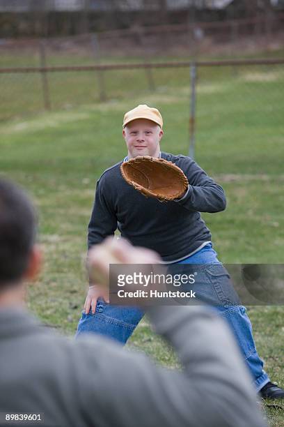Disabled man playing baseball with his son