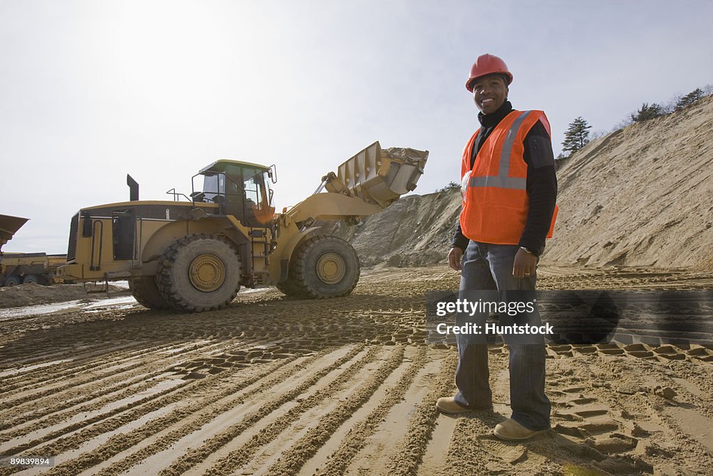 Engineer at a construction site with a front-end loader in the background