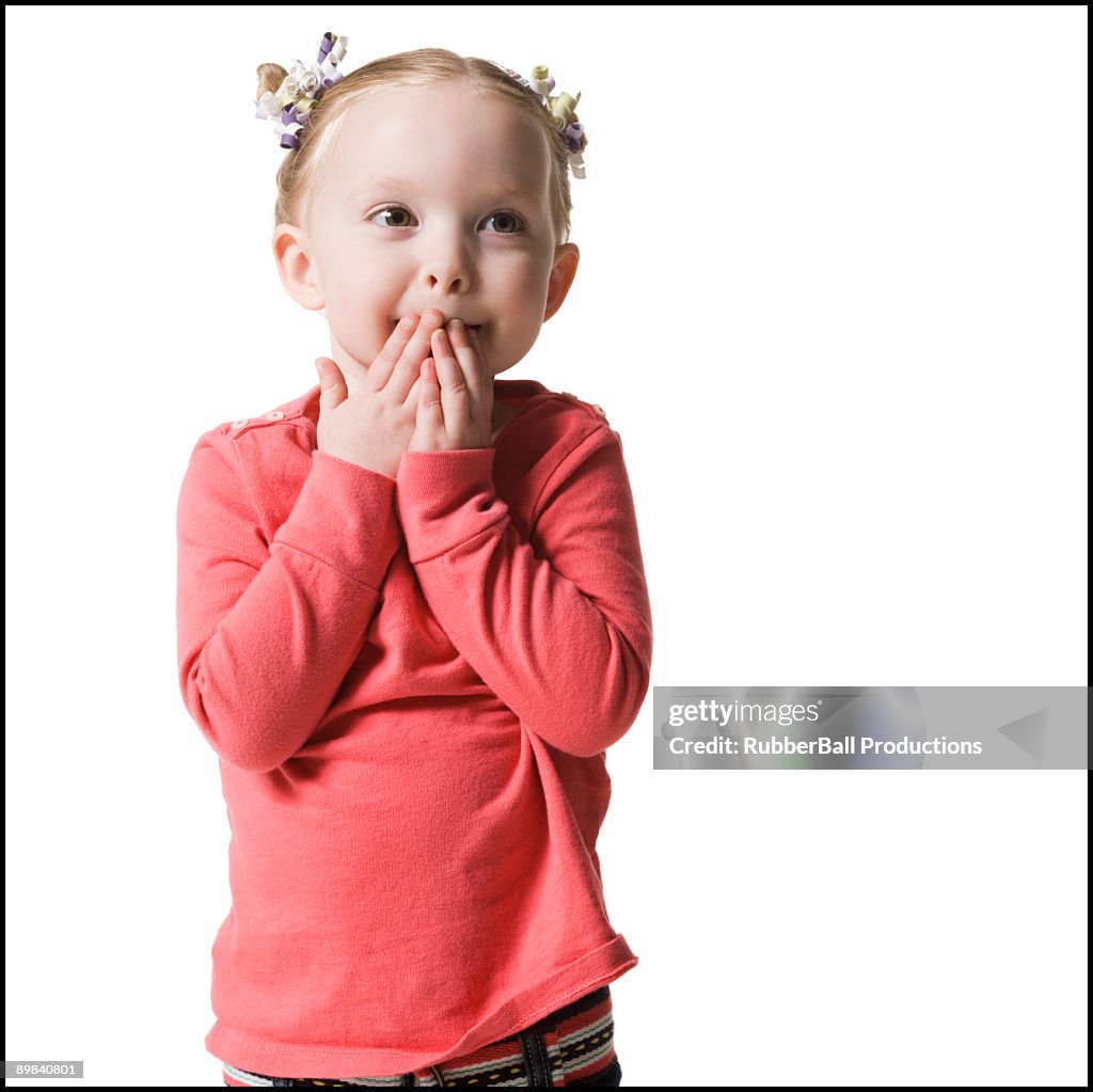 Girl with hands over mouth