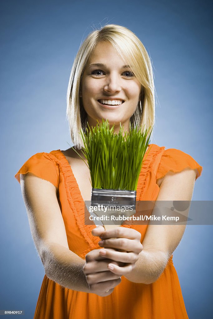 Woman holding a grass paintbrush