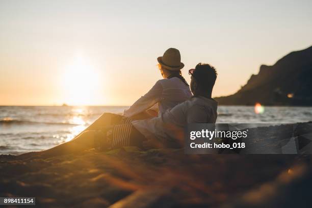 junges paar am strand von griechenland im sonnenuntergang - griechenland landschaft stock-fotos und bilder