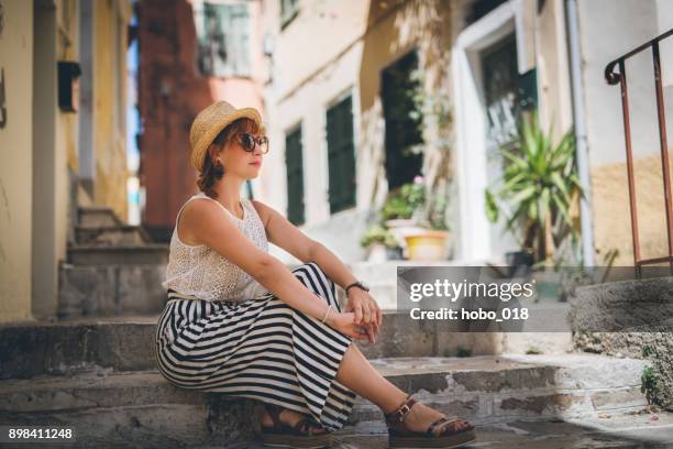 tourist woman in old city taking a rest from walking - corfu town stock pictures, royalty-free photos & images