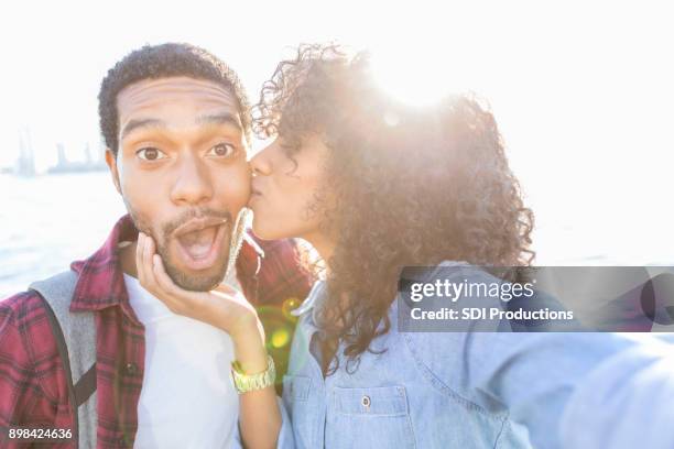joven recibe gracias beso de esposa de vacaciones - friends kissing cheeks fotografías e imágenes de stock