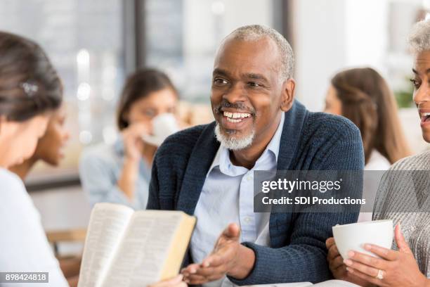 grupo diverso de personas estudiando la biblia - teología fotografías e imágenes de stock