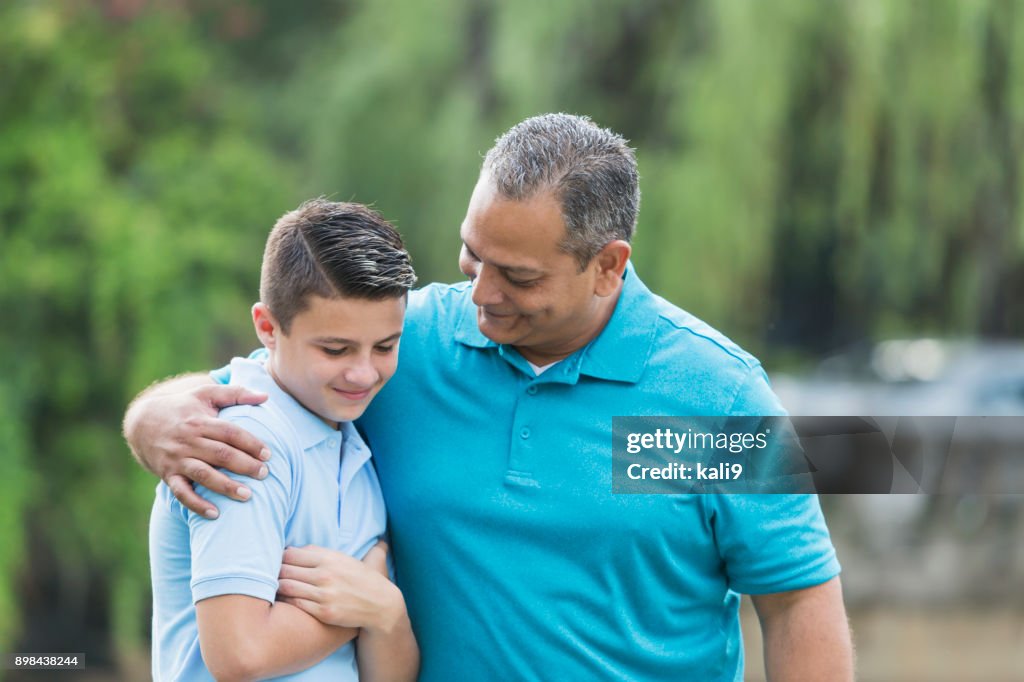 Hispanic man talking with teenage son