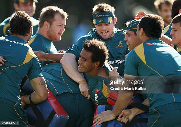 Will Genia is tackled by his team mates during an Australian Wallabies training session at Leichhardt Oval on August 18, 2009 in Sydney, Australia.