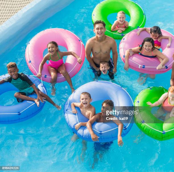multi-ethnic group of children, teen boy on lazy river - lazy river stock pictures, royalty-free photos & images